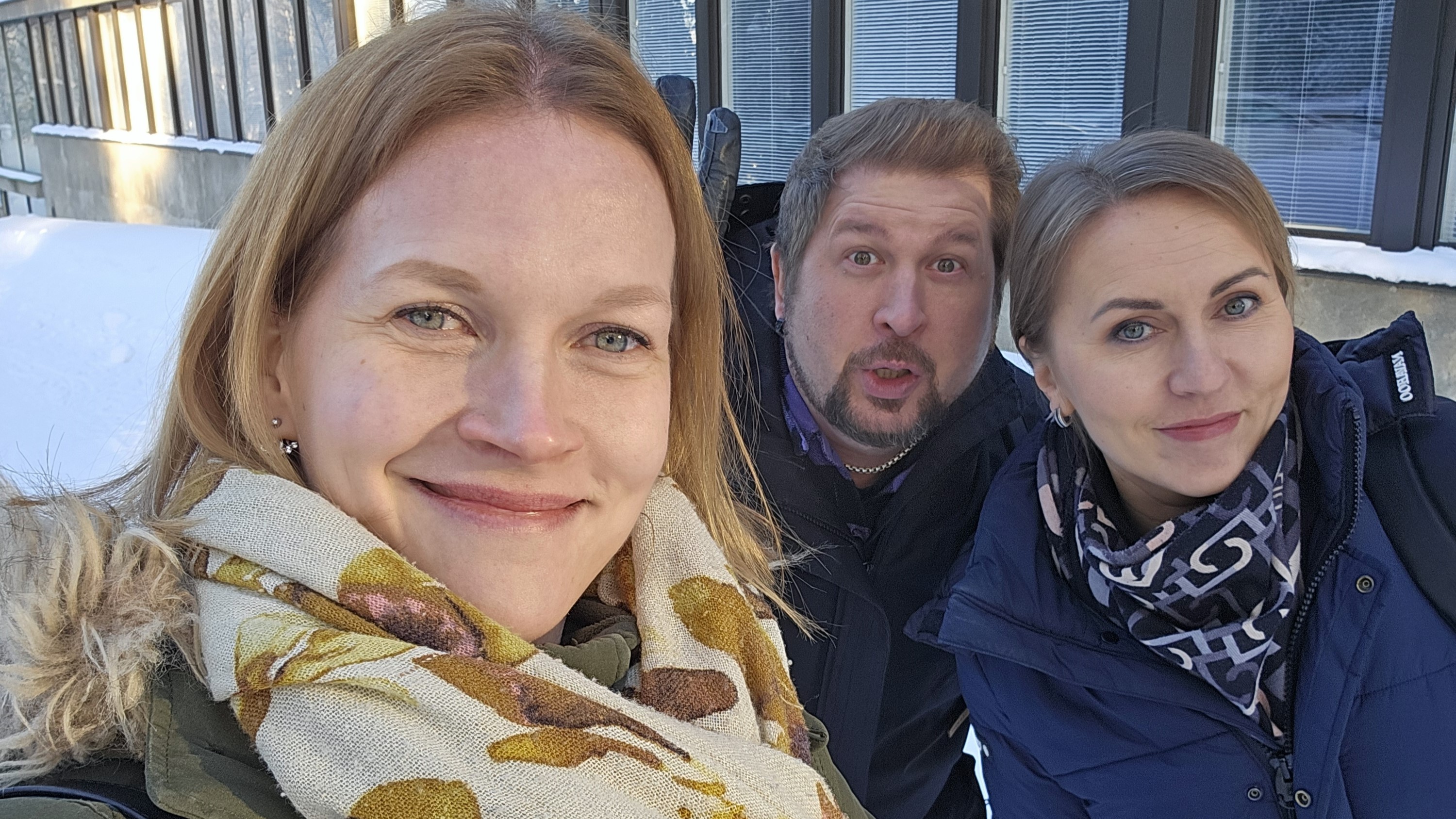 Kolme henkilöä lähikuvassa. Kuva on otettu ulkona talvella.
