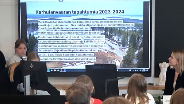 Nuori oppilas seisoo ison näytön luona ja kertoo näytöllä olevasta kuvasta.