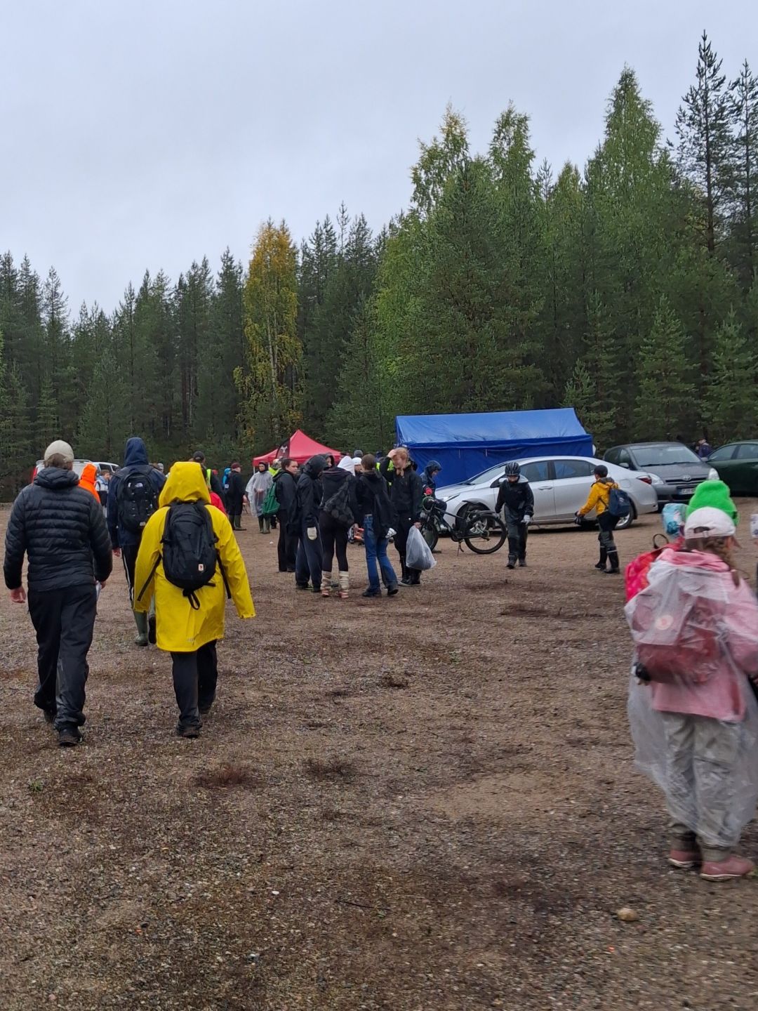 Porukkaa selin kuvaajaan hiekkakentällä.