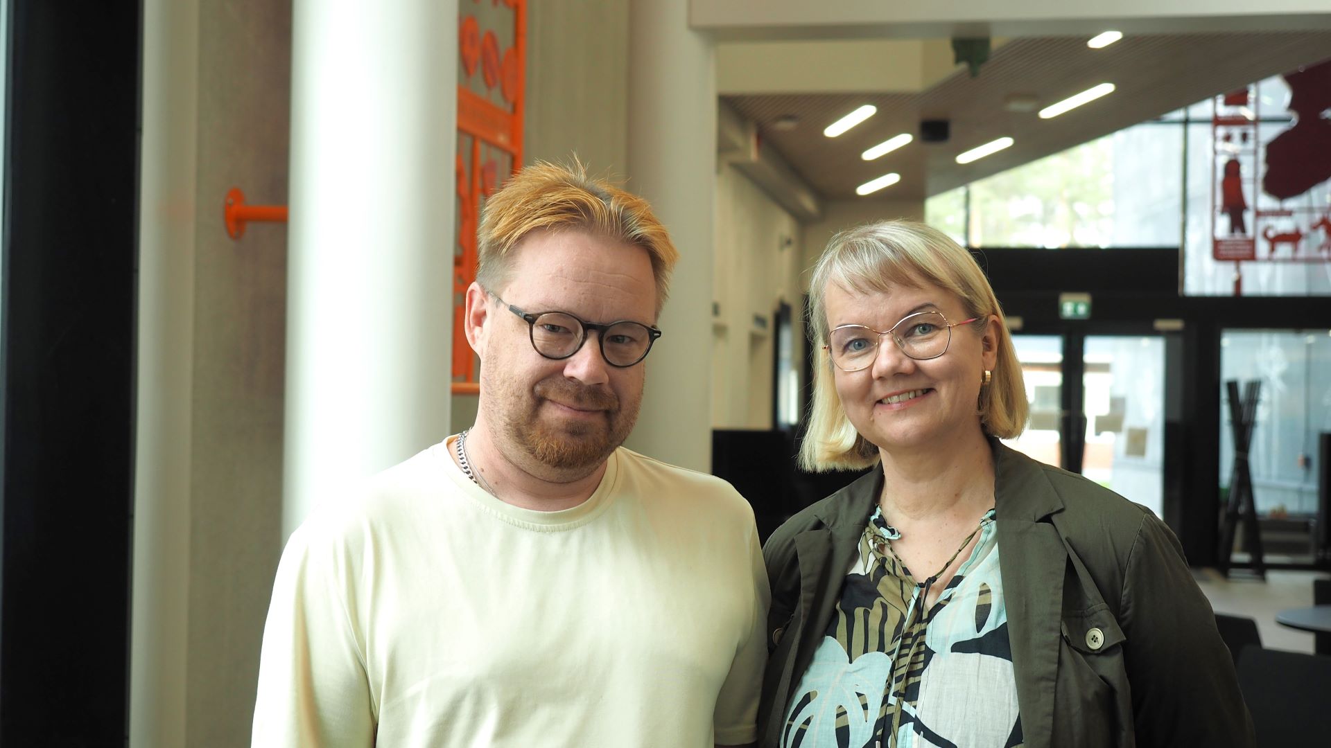 Kaksi hymyilevää henkilöä seisoo vierekkäin lähikuvassa.