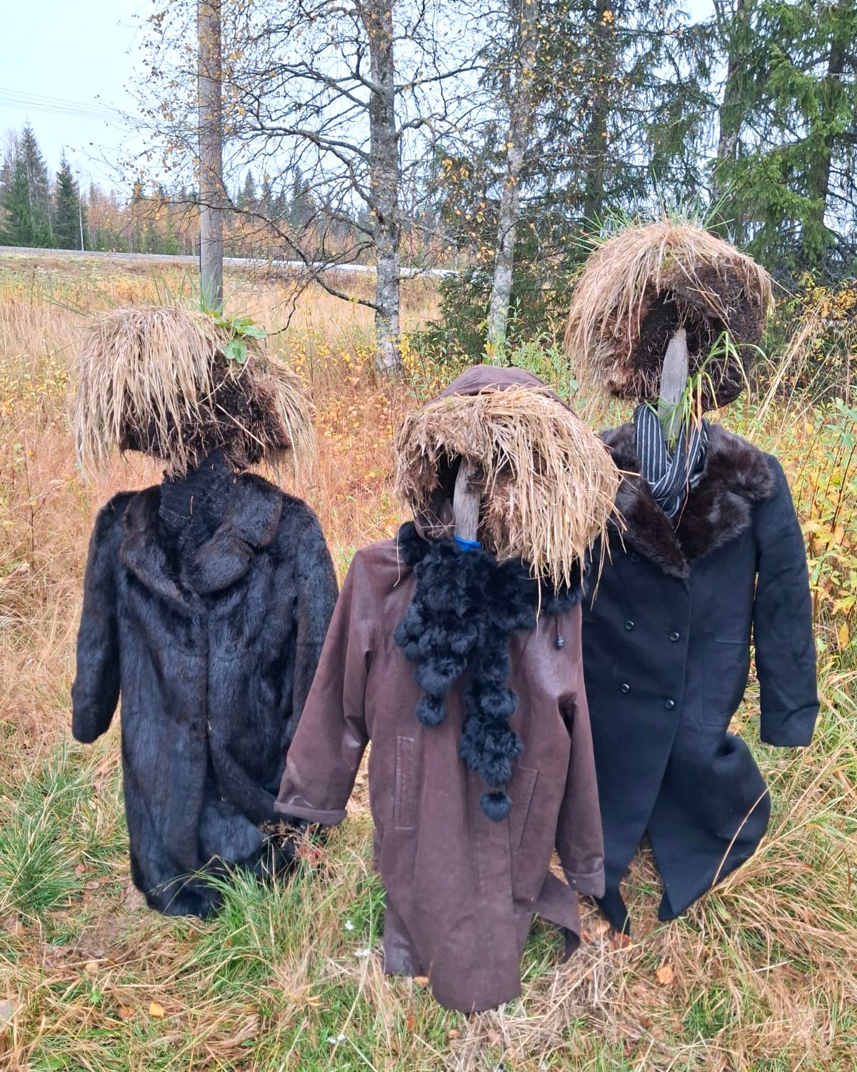 Kolme Hiljaisen kansan hahmoa yllään hienot talvitakit tai -turkit. 