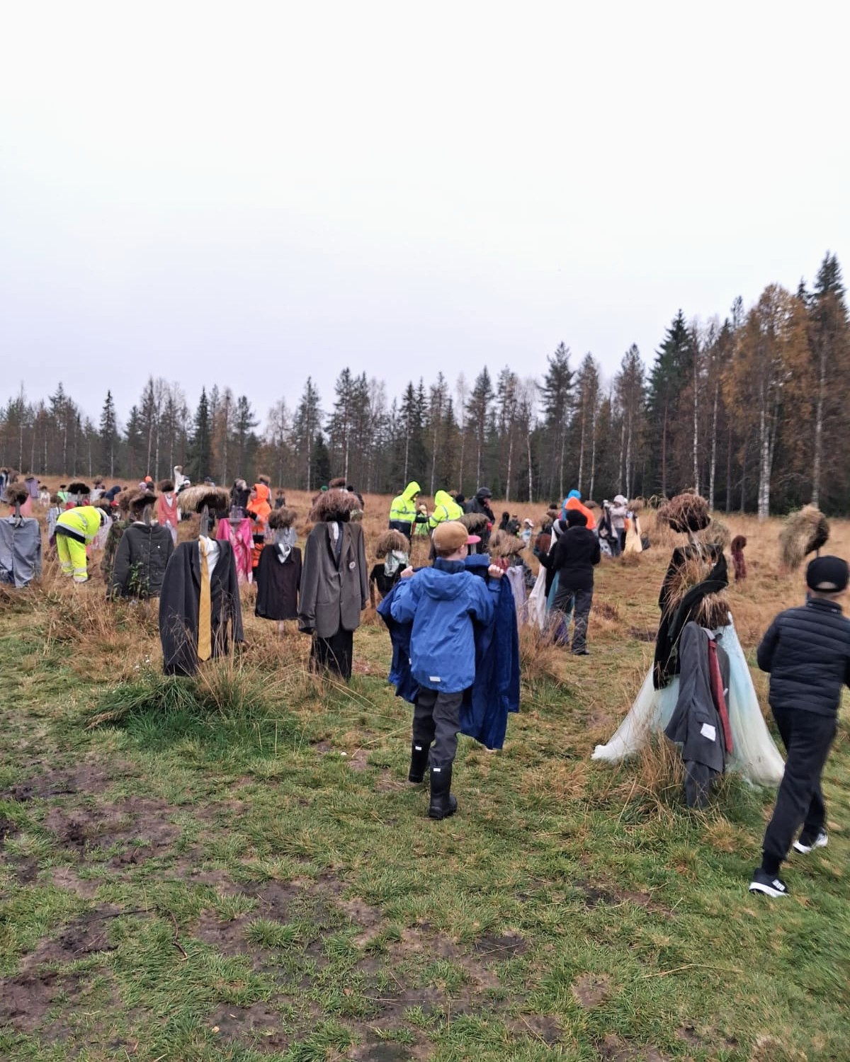 Joukko Hiljaisen kansan hahmoja, seassa talkoolaisia. 