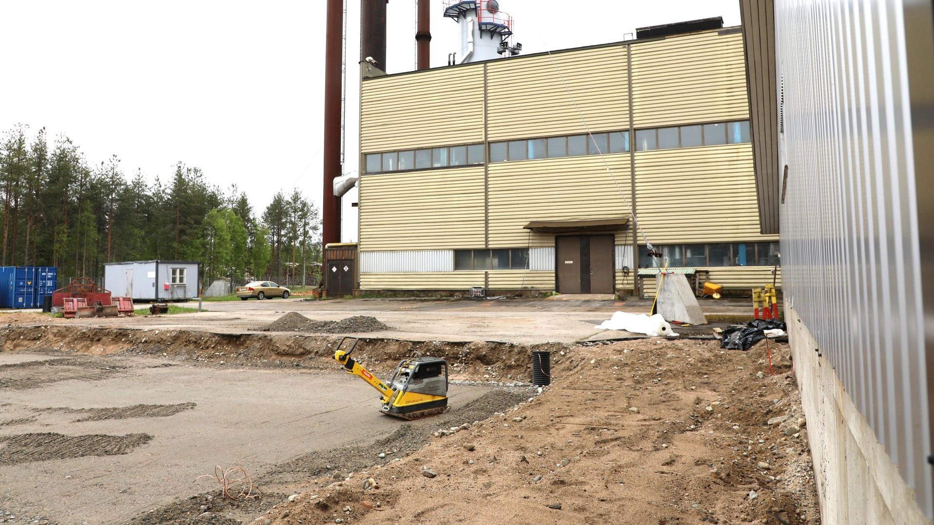 Etualalla tasoitettua maata, sen takana lämpölaitoksen seinää.