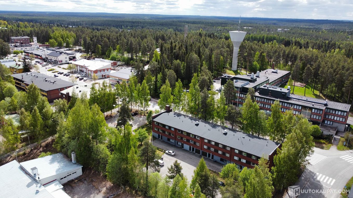 kesällä otettu ilmakuva, lähimpänä näkyy punatiilinen kolmekerroksinen kerrostalo.